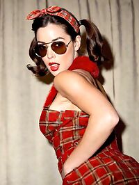 Sultry 27 year old in a red backless outfit pigtails and aviators on a dawn theater stage